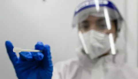 epa08800271 A health worker poses with a swab at a Covid-19 test center at Berlin Brandenburg Airport BER airport in Berlin, Germany, 05 November 2020. The company Centogene runs a walk-in COVID-19 test center at Berlin Brandenburg Airport and other airports in Germany. EPA/CLEMENS BILAN