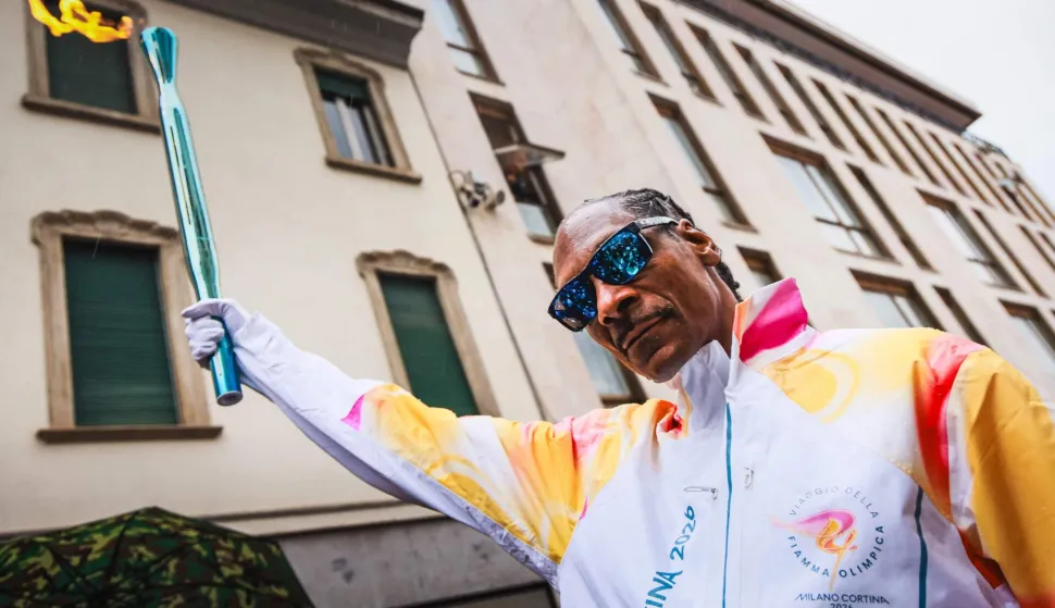 TOPSHOT - This handout picture taken and released on February 04, 2026 by the Milano Cortina 2026 Olympic Committee shows US rapper Snoop Dogg carrying the torch of the Olympic flame in Gallarate, ahead of Milano Cortina 2026 Olympic Games. (Photo by Handout/Milano Cortina 2026 Olympic Committee/AFP)/RESTRICTED TO EDITORIAL USE - MANDATORY CREDIT "AFP PHOTO/MILANO CORTINA 2026 OLYMPIC COMMITTEE" - HANDOUT - NO MARKETING NO ADVERTISING CAMPAIGNS - DISTRIBUTED AS A SERVICE TO CLIENTS