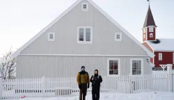 Two journalists stand in front of a Greenlandic house during Canadian Foreign Minister Anita Anand?s visit for the opening of the Canadian consulate in Nuuk, Greenland on February 6, 2026. Canada and France, which both oppose US President Donald Trump's claim to Greenland, open consulates in the Danish autonomous territory's capital on February 6, 2026, in a strong show of support for the local government. (Photo by Florent VERGNES/AFP)