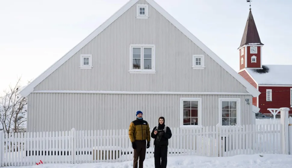 Two journalists stand in front of a Greenlandic house during Canadian Foreign Minister Anita Anand?s visit for the opening of the Canadian consulate in Nuuk, Greenland on February 6, 2026. Canada and France, which both oppose US President Donald Trump's claim to Greenland, open consulates in the Danish autonomous territory's capital on February 6, 2026, in a strong show of support for the local government. (Photo by Florent VERGNES/AFP)