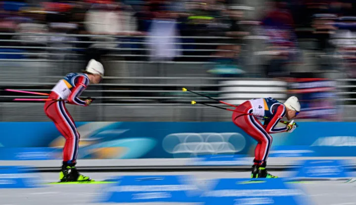 Norway's Johannes Hoesflot Klaebo (L) and Norway's Martin Loewstroem Nyenget compete during the men's cross country 10km + 10km skiathlon event of the Milano Cortina 2026 Winter Olympic Games at Tesero Cross-Country Skiing Stadium in Lago di Tesero (Val di Fiemme), on February 8, 2026. (Photo by Tobias SCHWARZ/AFP)