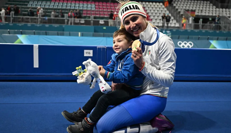 TOPSHOT - Gold medallist Italy's Francesca Lollobrigida poses with her son Tommaso after competing in the speed skating women's 3000m during the Milano Cortina 2026 Winter Olympic Games at Milano Speed Skating Stadium in Milan on February 7, 2026. (Photo by Gabriel BOUYS/AFP)