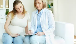Young pregnant woman listening to prescription of doctor after regular examination at hospitaltrudnoca