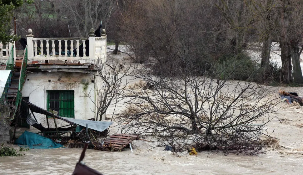 A house is surrounded by the Aguas Blancas river's floodwaters in Quentar, southern Spain amid Storm Leonardo, on February 5, 2026. Spain today lifted its highest weather alert for torrential rain in the southern region of Andalusia, where a woman went missing, a day after the storm killed one in Portugal. Storm Leonardo dumped more than 40 centimetres (15 inches) of rain in some Andalusian districts yesterday, forcing the evacuation of thousands, paralysing rail and road transport and shutting schools. The downpours, which came after a storm killed five people and left hundreds injured in neighbouring Portugal last week, are examples of extreme weather that scientists say climate change is worsening. (Photo by Thomas COEX/AFP)