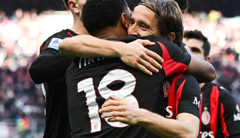 AC Milan's French forward #18 Christopher Nkunku (L) celebrates with AC Milan's Croatian midfielder #14 Luka Modric (R) after scoring his team second goal during the Italian Serie A football match between AC Milan and Hellas Verona at the San Siro stadium in Milan, northern Italy, on December 28, 2025. (Photo by Piero CRUCIATTI/AFP)