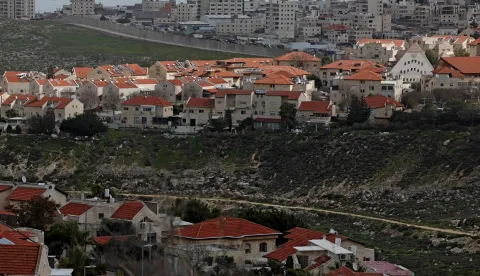 Israel's controversial barrier is pictured separating the Israeli settlement of Pisgat Zeev (foreground), built in a suburb of the predominantly-Arab and Israeli-annexed East Jerusalem, and the Palestinian village of Anata (background) on February 11, 2026. (Photo by AHMAD GHARABLI/AFP)