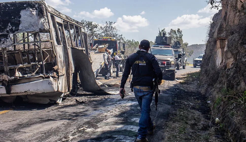 A convoy of the Mexican Army passes by vehicles allegedly set on fire by members of organized crime on the road between Morelia and Patzcuaro, Michoacan state, Mexico on February 22, 2026. Mexico confirmed on February 22, 2026, that soldiers killed a powerful drug cartel leader who was one of the most wanted men here and in the United States. Nemesio Oseguera, the 59-year-old leader of the violent Jalisco New Generation Cartel, was wounded in a clash with soldiers in the town of Tapalpa and died while being flown to Mexico City, the army said in a statement. (Photo by Enrique CASTRO/AFP)