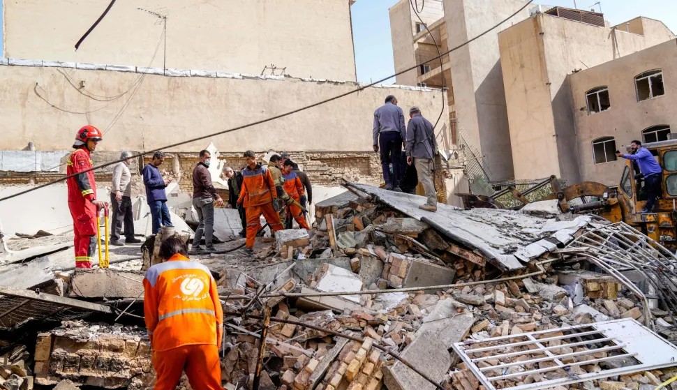TOPSHOT - In this picture obtained from Iran's ISNA news agency, rescuers search through the rubble of a collapsed building at the site where a missile hit a neighborhood, in Tehran on February 28, 2026. The United States and Israel launched strikes against Iran on February 28, with Israel's public broadcaster reporting that supreme leader Ayatollah Ali Khamenei had been targeted, as the Islamic republic retaliated with barrages of missiles at Gulf states and Israel. (Photo by AMIR KHOLOUSI/ISNA/AFP)