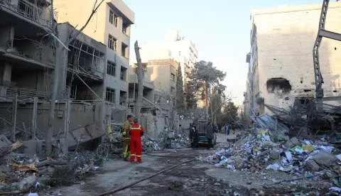 Firefighters and officials stand next to the rubble of residential buildings near Niloufar square in Tehran during the ongoing joint US-Israeli military campaign on Iran on March 2, 2026. The United States and Israel launched strikes against Iran on February 28, killing Iran's supreme leader and top military leaders, prompting authorities to retaliate with strikes on Israel and across the Gulf. (Photo by AFP)