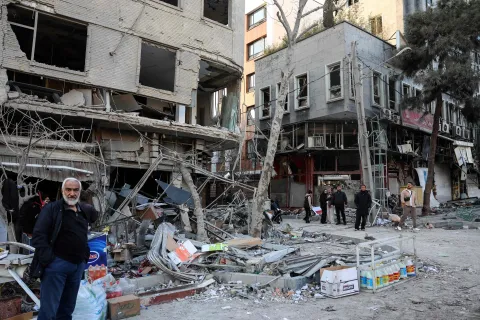 Residents stand on a street beside damaged residential buildings near Niloufar square in Tehran during the ongoing joint US-Israeli military campaign on Iran on March 2, 2026. The United States and Israel launched strikes against Iran on February 28, killing Iran's supreme leader and top military leaders, prompting authorities to retaliate with strikes on Israel and across the Gulf. (Photo by AFP)