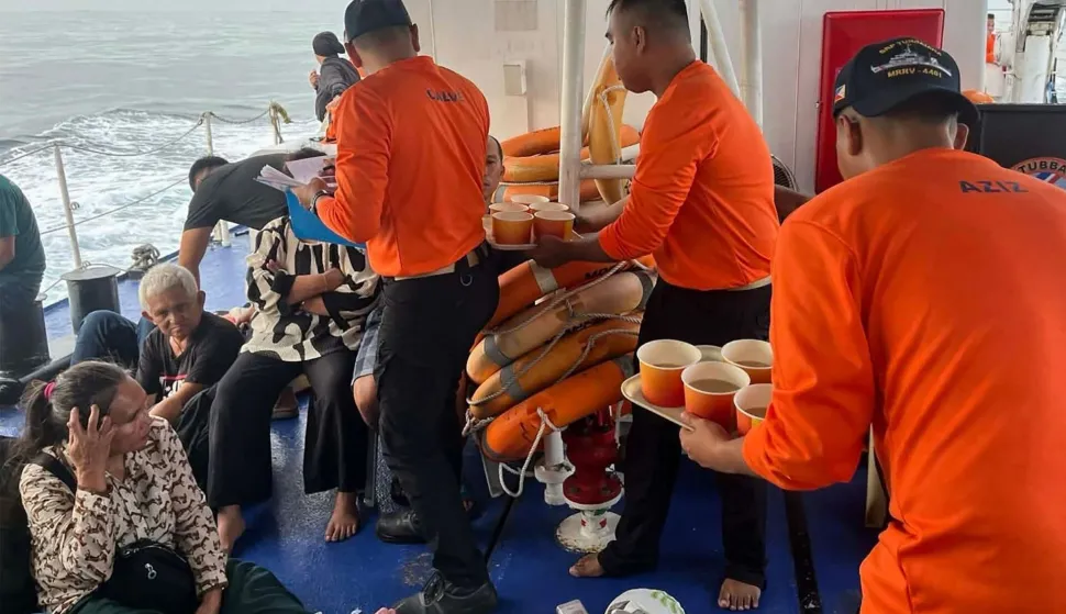 (FILES) This handout photo from the Philippine Coast Guard (PCG) taken and received on January 26, 2026 shows coast guard crew attending to the survivors of the sunken M/V Trisha Kerstin 3 in waters off Basilan province. Philippine authorities said on February 11 that a ferry may have been overloaded when it sank in the country's south last month, killing dozens of people who received no warning from the ship's crew. The death toll has risen steadily since the Trisha Kerstin 3 went down off the coast of southwestern Mindanao on January 26, with the body of a woman pulled from the wreckage by divers on the morning of February 11 bringing the tally to 52. (Photo by Handout/Philippine Coast Guard (PCG)/AFP)/RESTRICTED TO EDITORIAL USE - MANDATORY CREDIT "AFP PHOTO/Philippine Coast Guard (PCG)" - HANDOUT - NO MARKETING NO ADVERTISING CAMPAIGNS - DISTRIBUTED AS A SERVICE TO CLIENTS