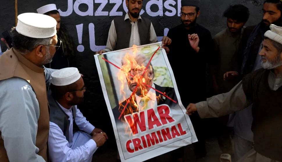 TOPSHOT - Activists and supporters of the Jamaat-e-Islami party burn a poster of US President Donald Trump during an anti-US and Israel protest in Peshawar on March 2, 2026 after the death of Iran's supreme leader Ayatollah Ali Khamenei amid US-Israel strikes. The death toll from Pakistan's violent weekend protests over the killing of Iran's supreme leader has reached at least 25, according to an AFP tally on March 2. (Photo by Abdul MAJEED/AFP)