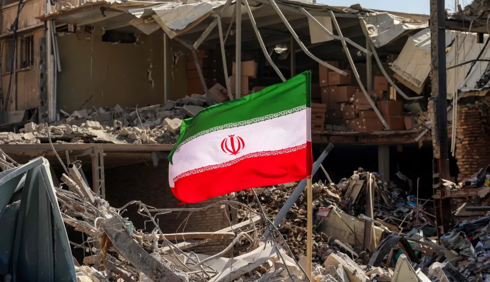 An Iranian flag is placed amids rubble and debris next to a destroyed residential building near Ferdowsi square in Tehran on March 3, 2026. The United States and Israel started striking Iran on February 28, killing Iran's supreme leader and top military leaders, and prompting authorities to retaliate with strikes on Israel and across the Gulf. (Photo by ATTA KENARE/AFP)