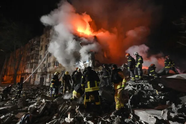 Firefighters extinguish a blaze and clear rubble at a five-story residential building in Kharkiv on March 7, 2026, after it was partially destroyed by a Russian strike amid the Russian invasion of Ukraine. Ukraine issued a nationwide air alert early on March 7, as Russian strikes wounded 10 people in the Kharkiv region, authorities said. Kharkiv regional military chief Oleg Synegubov said at least three people were treated in hospital, including an 11-year-old boy, after a strike on a residential building. (Photo by SERGEY BOBOK/AFP)