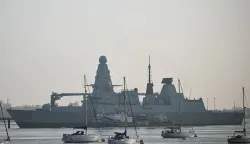 HMS Dragon, a Type 45 Daring-class air-defence destroyer warship, is pictured moored at the HMNB Portsmouth Upper Harbour Ammunition Facility (UHFC), outside HM Naval Base Portsmouth, on the south coast of England, on March 4, 2026. British Prime Minister Keir Starmer said March 3, 2026 that the UK was dispatching "helicopters with counter drone capabilities" and a warship, HMS Dragon, to Cyprus as Britain continues "defensive operations" in the region. His announcement comes after Britain's Royal Air Force (RAF) Akrotiri base was struck early Monday by an Iranian-made drone, which hit the runway. (Photo by Justin TALLIS/AFP)