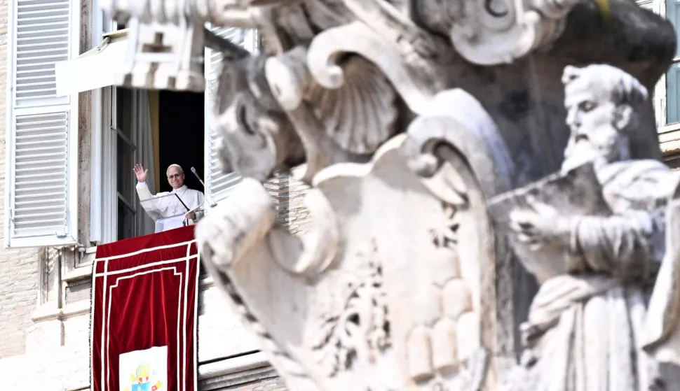 Pope Leo XIV addresses the crowd from a window of the apostolic palace overlooking St. Peter's Square during the Angelus prayer in The Vatican on March 8, 2026. (Photo by TIZIANA FABI/AFP)