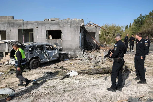 Israeli policemen secure the site of a rocket strike in Zarzir, northern Israel, on March 13, 2026. New waves of attacks struck Iran and Gulf nations on March 13 after Tehran renewed its threats on oil facilities, while France announced its first soldier killed during the Mideast war. The latest strikes on Iran hit over 200 targets in the past day, Israel's military said well into the second week of the US-Israeli campaign that has grown into a deadly regional fight causing economic chaos. (Photo by Odd ANDERSEN/AFP)/
