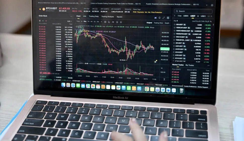 This photo taken on February 12, 2026 shows a Vietnamese cryptocurrency investor looking at the latest Bitcoin values on a laptop in Hanoi. As a first-year computer science student in Hanoi, Hoang Le started trading crypto from his university dorm room, egged on by his gamer friends who were making a killing, and at one point his digital holdings swelled to $200,000 -- around 50 times the average annual income in Vietnam. But they crashed to zero when the bottom fell out of bitcoin and other cryptocurrencies in recent months. (Photo by Nhac NGUYEN/AFP)/To go with 'VIETNAM-ECONOMY-CRYPTO,FOCUS' by Lam NGUYEN