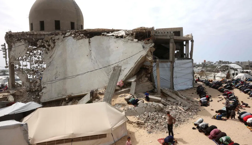 Palestinian Muslims pray during the last Friday noon prayer of the Muslim holy fasting month of Ramadan, outside the Al-Talbani Mosque, destroyed by the Israeli military in Khan Yunis, in the southern Gaza Strip on March 13, 2026. (Photo by Bashar Taleb/AFP)