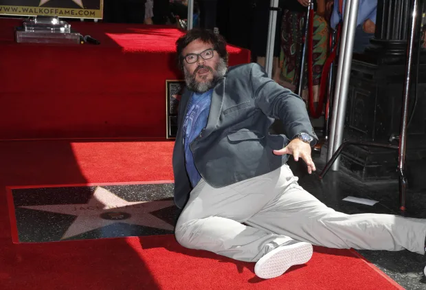 epa07031142 US actor Jack Black lies down next to his star during a ceremony honoring him on the Hollywood Walk of Fame in Hollywood, California, USA, 18 September 2018. Black received the 2,645th star in the category of Motion Pictures. EPA/MIKE NELSON