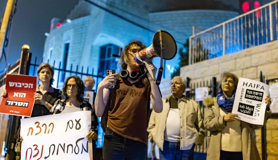 Protestors hold banners during an anti-war protest in Haifa on March 14, 2026. On February 28, Israel and the United States launched strikes on Iran, killing its supreme leader and triggering a war that spread across the Middle East. (Photo by Odd ANDERSEN/AFP)/