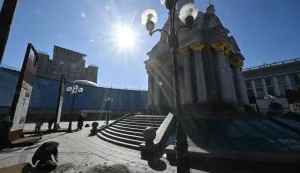Journalists work at the site where debris from downed Russian drones crashed following a drone and missile attack, on Independence Square in Kyiv on March 16, 2026 amid the Russian invasion of Ukraine. (Photo by Sergei SUPINSKY/AFP)