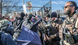 Law enforcement stands guard as protestors demonstate outside the Bishop Henry Whipple Federal Building during a protest opposing US Immigration and Customs Enforcement (ICE) operations, in Minneapolis, Minnesota, on March 1, 2026. The demonstration was organized in connection with a prayer camp established across the street at the sacred site of Mni Owe Sni (Coldwater Spring), where Indigenous organizers have been gathering in recent weeks to pray for families affected by immigration enforcement and to call for ?ICE out? and ?Land Back.? Indigenous leaders say immigration enforcement and detention echo historic patterns of displacement and incarceration experienced by Native communities. The camp at Mni Owe Sni ? considered a sacred Dakota site ? was established to center ceremony, prayer and solidarity with immigrant families. (Photo by Kerem YUCEL/AFP)