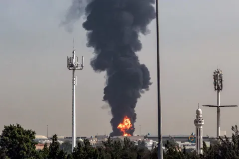 TOPSHOT - A smoke plume rises from an ongoing fire at Dubai International Airport in Dubai on March 16, 2026. Flights were gradually resuming at Dubai airport on March 16, previously the world's busiest for international flights, the airport operator said, after a "drone-related incident" sparked a fuel tank fire nearby, as Iran kept up its Gulf attacks. (Photo by AFP)/