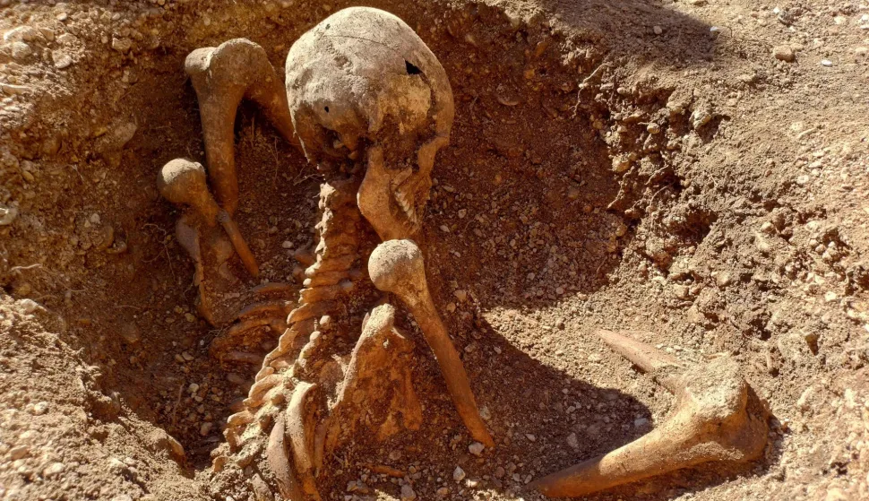 This photograph taken on March 17, 2026 shows an archeological dig site revealing gallic (Gaulois) burial sites in central Dijon, central-eastern France. In the very heart of Dijon, five new tombs of Gauls buried in a seated position have been discovered during preventive excavations ? rare types of burials that raise many questions. For the past few days, pupils at the Josephine Baker primary school group in Dijon have had a new attraction: a particularly well-preserved skeleton lying at the bottom of a circular pit, in an excavation area right next to their playground. (Photo by Fr?d?ric BOURIGAULT/AFP)