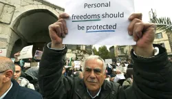 Syrians hold a silent sit-in, called for by civil society, Christians, and shop owners affected by an official decision banning the sale of alcoholic beverages except in specific locations and demanding an end to state interference in personal freedoms and the sectarian division of society, in Bab Touma in Damascus on March 22, 2026. Syria's capital on March 16, 2026, restricted the sale of alcoholic beverages to select Christian neighbourhoods, the latest incident hinting at increasing social conservatism under Islamist authorities. (Photo by LOUAI BESHARA/AFP)
