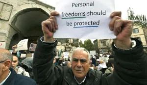 Syrians hold a silent sit-in, called for by civil society, Christians, and shop owners affected by an official decision banning the sale of alcoholic beverages except in specific locations and demanding an end to state interference in personal freedoms and the sectarian division of society, in Bab Touma in Damascus on March 22, 2026. Syria's capital on March 16, 2026, restricted the sale of alcoholic beverages to select Christian neighbourhoods, the latest incident hinting at increasing social conservatism under Islamist authorities. (Photo by LOUAI BESHARA/AFP)