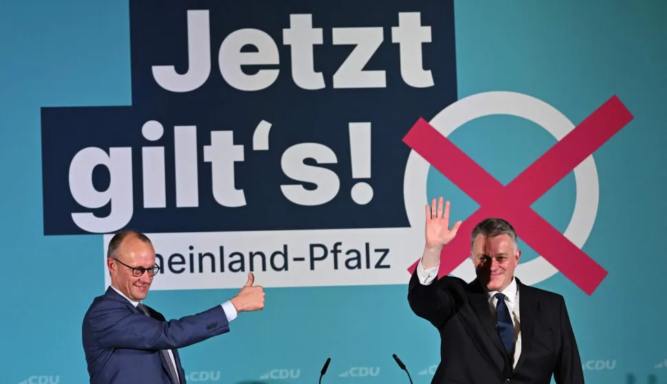 German Chancellor Friedrich Merz (L) gives the thumbs up sign on stage at a campaign event in support of Gordon Schnieder (R), Christian Democratic Union (CDU) top candidate in the State elections in Rhineland-Palatinate in Bad Duerkheim, western Germany on March 22, 2026. (Photo by Hannes P. Albert/AFP)