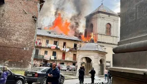 In this handout photograph taken and posted on the official Telegram channel of Lviv mayor on March 24, 2026, people stand next to a burning building following an air attack in Lviv, amid the Russian invasion of Ukraine. A barrage of Russian missiles and drones killed five people and wounded more than two dozen across Ukraine on March 24, 2026 in the largest attack in weeks, officials said. (Photo by Handout/TELEGRAM /@andriysadovyi/AFP)/RESTRICTED TO EDITORIAL USE - MANDATORY CREDIT "AFP PHOTO/OFFICIAL TELEGRAM CHANNEL OF LVIV MAYOR ANDRIY SADOVY" - HANDOUT - NO MARKETING NO ADVERTISING CAMPAIGNS - DISTRIBUTED AS A SERVICE TO CLIENTS