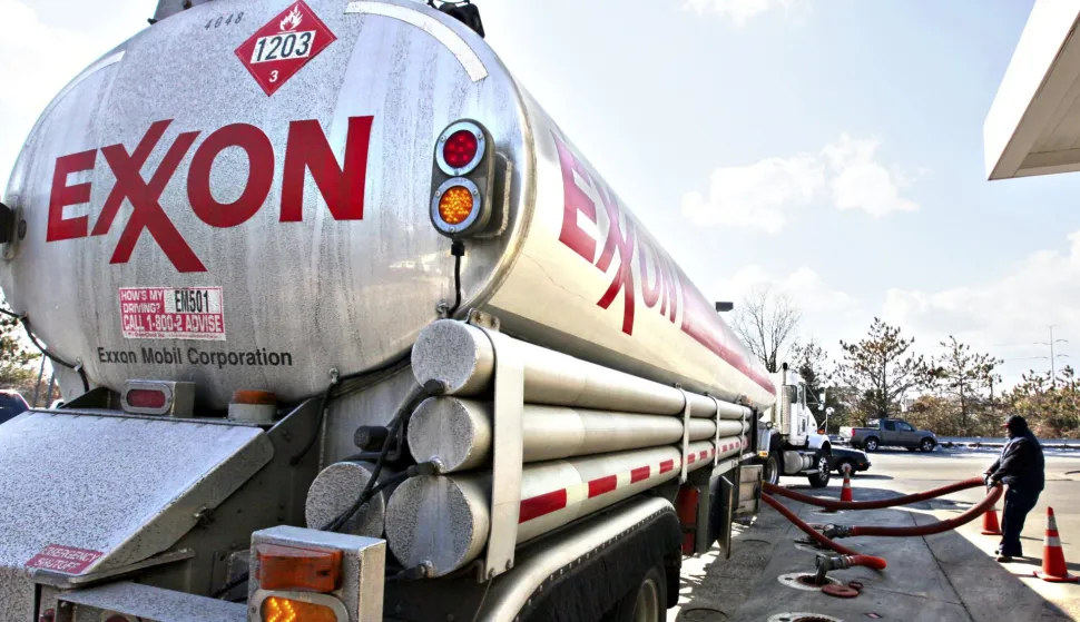 FILE - In this Jan. 30, 2009 file photo, an Exxon tanker truck operated by Corey Moorer, right, of Clinton, Md., makes a refueling stop at an Exxon station in Arlington, Va. Exxon Mobil said Monday, Feb. 1, 2010, its fourth-quarter earnings tumbled 23 percent as higher oil prices squeezed profit margins in its refining business.(AP Photo/J. Scott Applewhite, file)