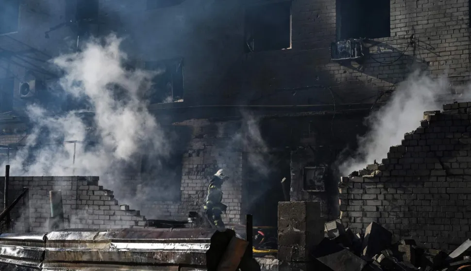 Firefighters extinguish a fire at a site of a strike in the town of Brovary, near Kyiv, following a Russian missile and drone attack, on March 14, 2026, amid the Russian invasion of Ukraine. Russian drone and missile strikes near Ukraine's capital killed two people and wounded four, the regional military administration said on March 14. "Sadly, two people have been killed in the Brovary Raion. Four more have been injured," said Mykola Kalashnyk, the head of Kyiv region's military administration, in a post on Telegram. (Photo by Genya SAVILOV/AFP)