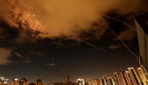 Rocket trails are seen in the sky above the Israeli coastal city of Netanya amid a fresh barrage of Iranian missile attacks on March 25, 2026. (Photo by JACK GUEZ/AFP)/
