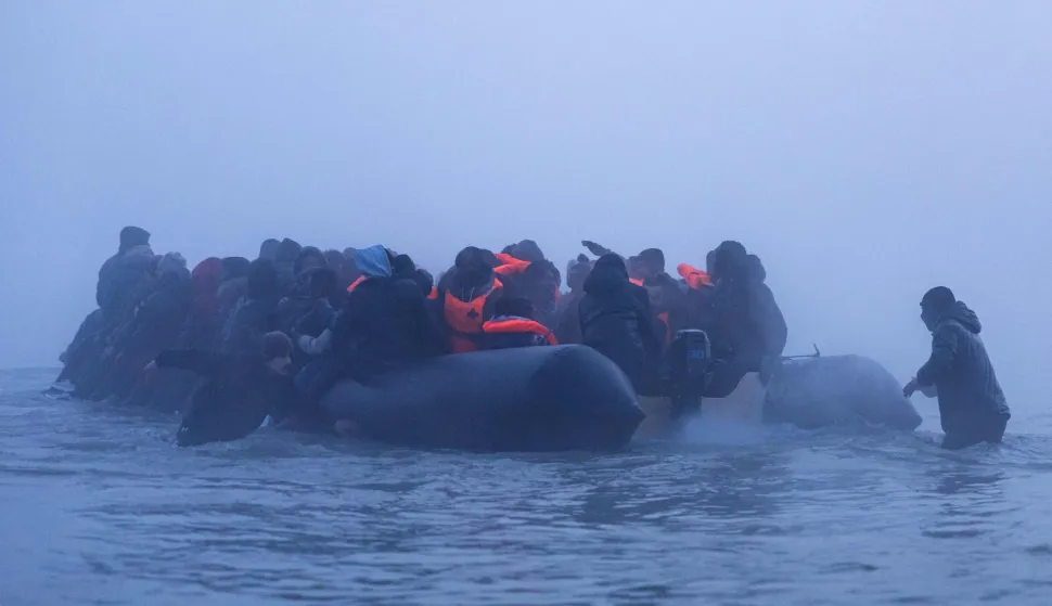 Smugglers assist migrants to board a boat in an attempt to cross the English Channel off the beach of Gravelines, northern France, on March 4, 2026. (Photo by Sameer Al-DOUMY/AFP)
