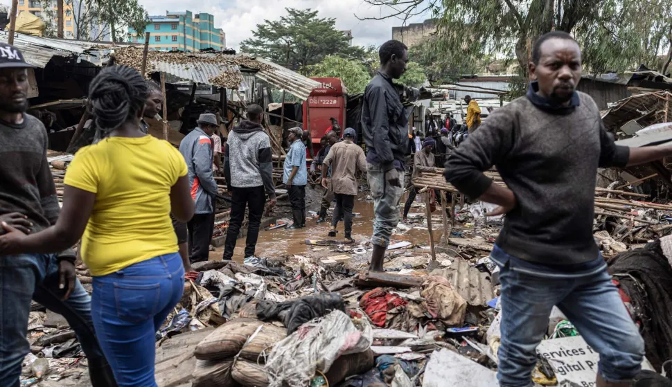 TOPSHOT - People walk around damaged property looking for salvageables in downtown Nairobi following a night of heavy rainfall that resulting in heavy flooding around Nairobi on March 07, 2026. (Photo by Tony KARUMBA/AFP)