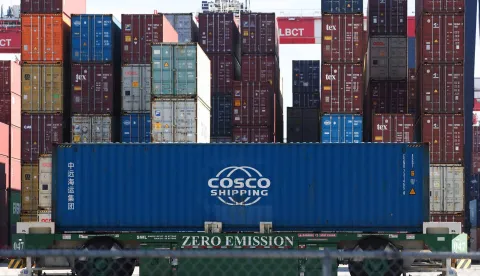 (FILES) An automated guided vehicle container handler moves a Cosco shipping container at the Long Beach Container Terminal (LGCT) at the Port of Long Beach in California on January 14, 2026. Chinese shipping giant Cosco, which operates one of the world's biggest oil tanker fleets, said it is suspending from Match 4, 2026, services to and from Gulf countries including the UAE, Bahrain, Saudi Arabia, Iraq and Kuwait. (Photo by Patrick T. Fallon/AFP)