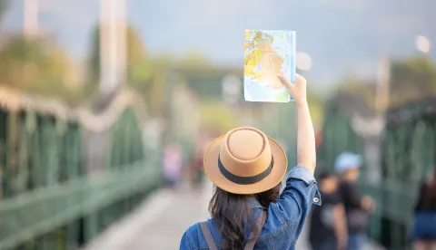 Female tourists on hand have a happy travel map.