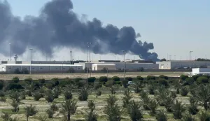 TOPSHOT - Smoke rises from an area of Kuwait's international airport after a reported drone strike on April 1, 2026. Kuwait's civil aviation authority said that the Gulf state's international airport had come under an Iranian drone attack that led to "a large fire" at a fuel depot. (Photo by AFP)/Kuwait OUT/KUWAIT OUT