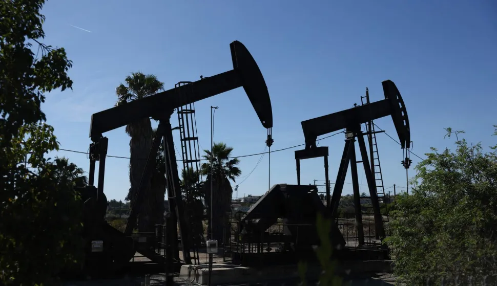 Pumpjacks operate at the Inglewood Oil field in Los Angeles, California on March 17, 2026. Asian markets mostly rose on March 18 and oil prices dipped following another tech-led advance on Wall Street, as the United States hit Iranian missile sites near the key Strait of Hormuz and Tehran struck crude-producing Gulf neighbours. While the war in the Middle East shows no sign of ending and oil has stuck around $100 a barrel -- threatening to fuel a fresh inflation spike -- equity traders have shifted back into the market after the steep losses suffered at the outset of the conflict. (Photo by Patrick T. Fallon/AFP)