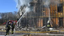 Ukrainian rescuers work to extinguish a fire in a damaged residential building following a drone attack in Kharkiv on April 2, 2026, amid the Russian invasion of Ukraine. (Photo by SERGEY BOBOK/AFP)
