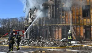 Ukrainian rescuers work to extinguish a fire in a damaged residential building following a drone attack in Kharkiv on April 2, 2026, amid the Russian invasion of Ukraine. (Photo by SERGEY BOBOK/AFP)