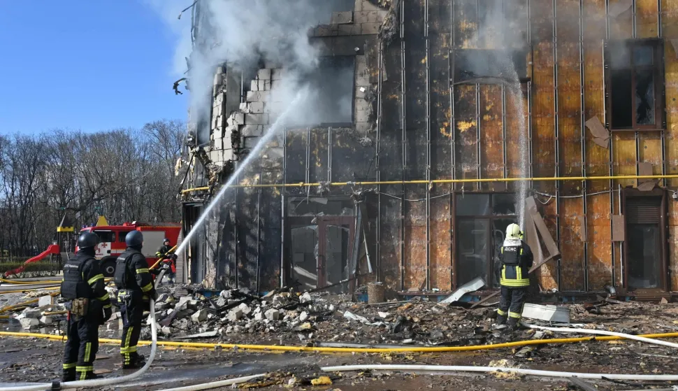 Ukrainian rescuers work to extinguish a fire in a damaged residential building following a drone attack in Kharkiv on April 2, 2026, amid the Russian invasion of Ukraine. (Photo by SERGEY BOBOK/AFP)