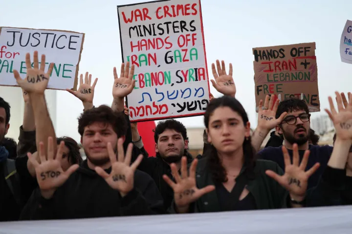 Israeli left-wing activists hold placards while taking part in a protest at HaBima Square in Tel Aviv on April 4, 2026, against the ongoing war with Iran. Carrying anti-war banners and chanting slogans against Prime Minister Benjamin Netanyahu, hundreds of Israelis rallied in Tel Aviv on March 4 to protest the war with Iran. Since February 28, the United States and Israel have conducted joint strikes against Iran, prompting the Islamic Republic to retaliate with daily missile barrages targeting Israel and several neighbouring countries across the region. (Photo by Ilia YEFIMOVICH/AFP)/