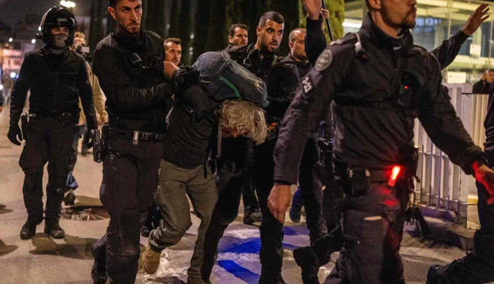 Israeli police arrest a demonstrator at HaBima Square in Tel Aviv on April 4, 2026, protesting against the ongoing war with Iran. Carrying anti-war banners and chanting slogans against Prime Minister Benjamin Netanyahu, hundreds of Israelis rallied in Tel Aviv on April 4 to protest the war with Iran. Since February 28, the United States and Israel have conducted joint strikes against Iran, prompting the Islamic Republic to retaliate with daily missile barrages targeting Israel and several neighbouring countries across the region. (Photo by Ilia YEFIMOVICH/AFP)/