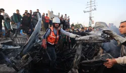 First responders and Plestinians inspect a vehicle targered by an Israeli strike in Maghazi camp for Palestinian refugees in the central Gaza Strip on April 4, 2026. Since October 10, a fragile US-sponsored truce in Gaza has largely halted the fighting between Israeli forces and Hamas, but both sides have alleged frequent violations. (Photo by Eyad Baba/AFP)