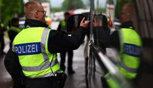 epa12082923 German police officers check papers at a checkpoint near the border with Austria, in Kiefersfelden, Germany, 08 May 2025. The new German interior minister said the country will increase controls along the borders as part of a tougher immigration policy. EPA/ANNA SZILAGYI