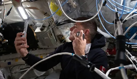 This handout image released by NASA shows Artemis II mission specialist and CSA (Canadian Space Agency) astronaut Jeremy Hansen shaving inside the Orion spacecraft during Flight Day 5 and ahead of the crew's lunar flyby on April 6, 2026. The Artemis astronauts entered the final phase of their run-up to a lunar loop on April 6, a tipping point of sorts that means the Moon's gravity is now having a stronger pull on the spacecraft than Earth's. The Orion capsule will now whip around the Moon, setting the crew up to travel farther from our home planet than any human before. (Photo by Handout/NASA/AFP)/RESTRICTED TO EDITORIAL USE - MANDATORY CREDIT "AFP PHOTO/NASA" - HANDOUT - NO MARKETING NO ADVERTISING CAMPAIGNS - DISTRIBUTED AS A SERVICE TO CLIENTS